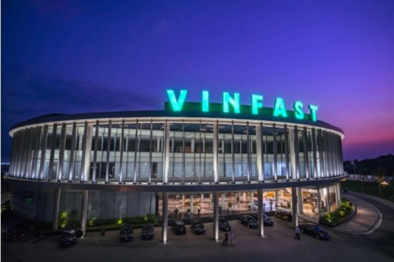 A sleek VinFast electric vehicle on display at a major international auto show, signifying its global debut.